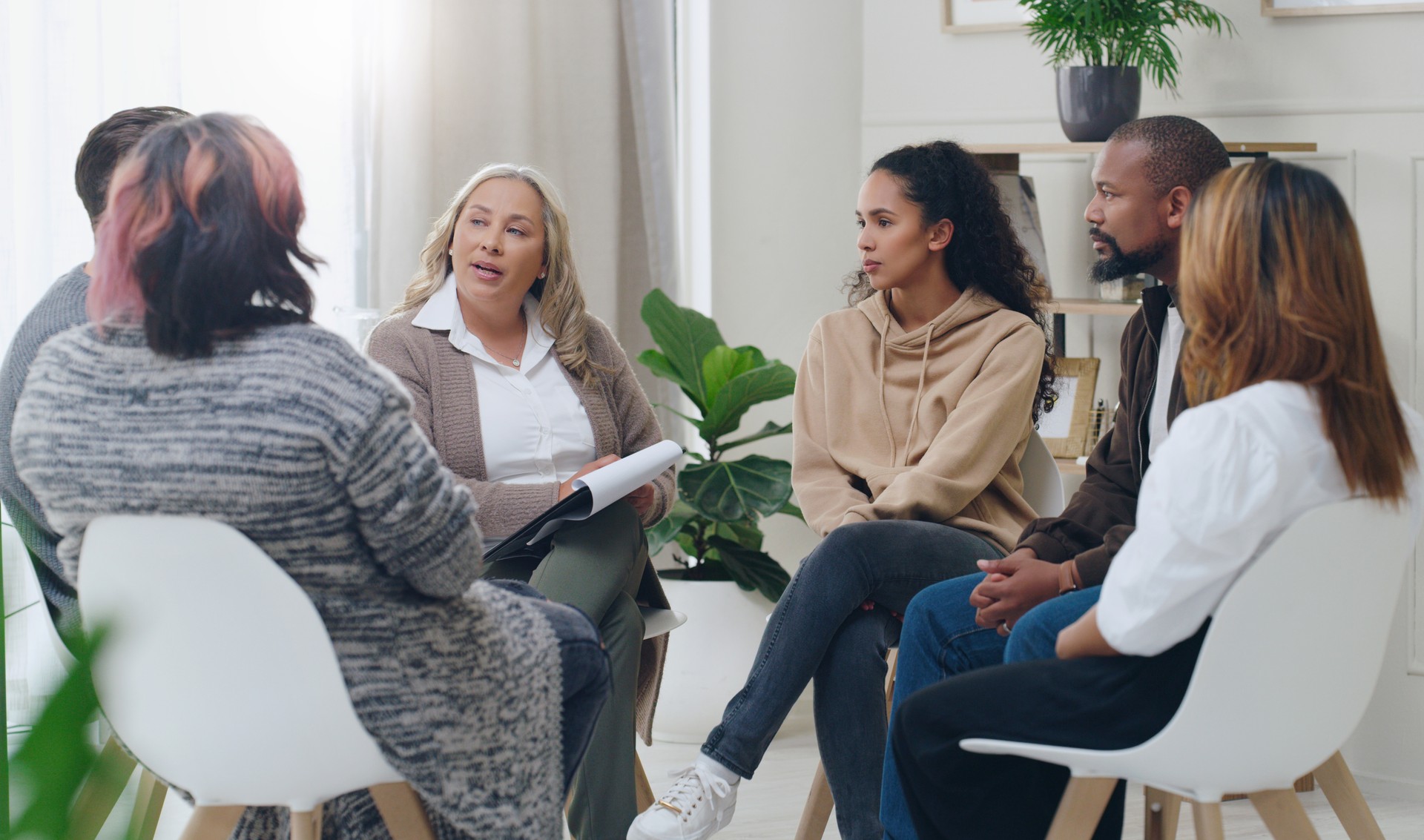 Counseling, group and psychology discussion with group of diversity people in therapy for depression, stress and anxiety. Men and women healing during psychologist meeting talking about mental health